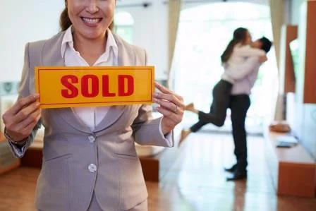 couple happily embrace after house sold for cash