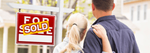 happy couple in front of home sold for cash