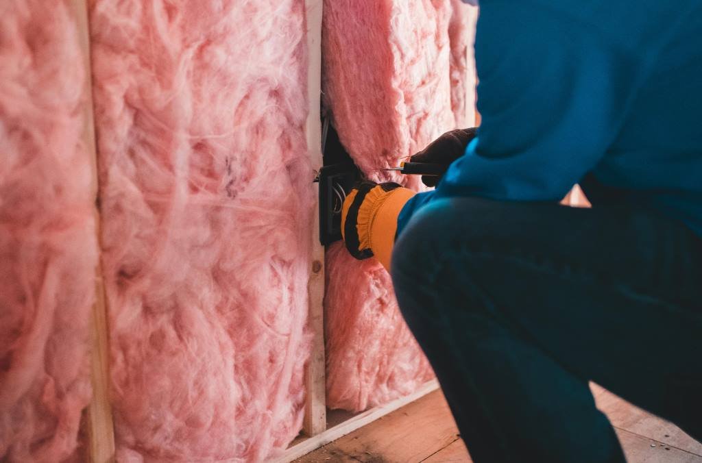 insulation being installed in a wall cavity